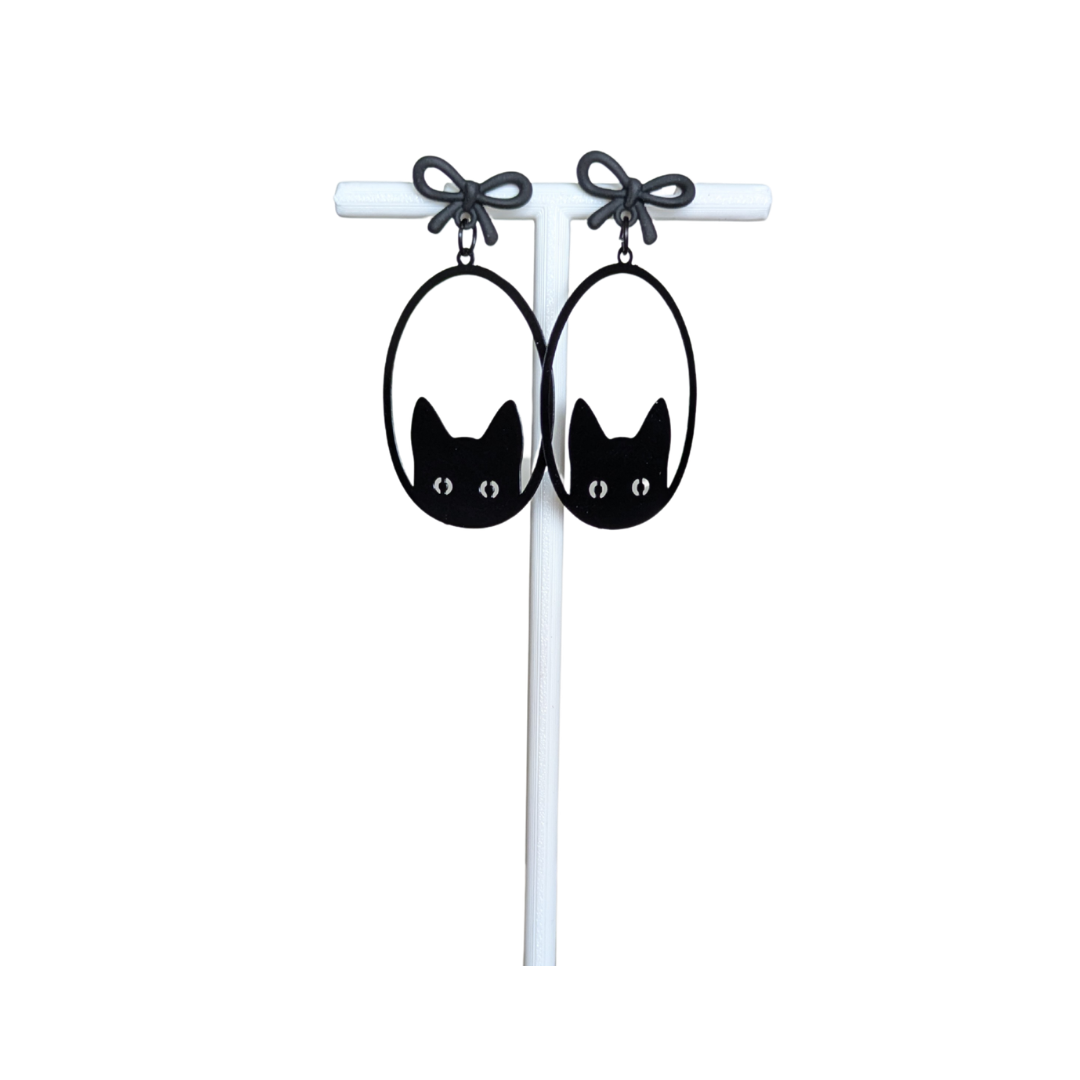 Black cat earrings with bows on a white background