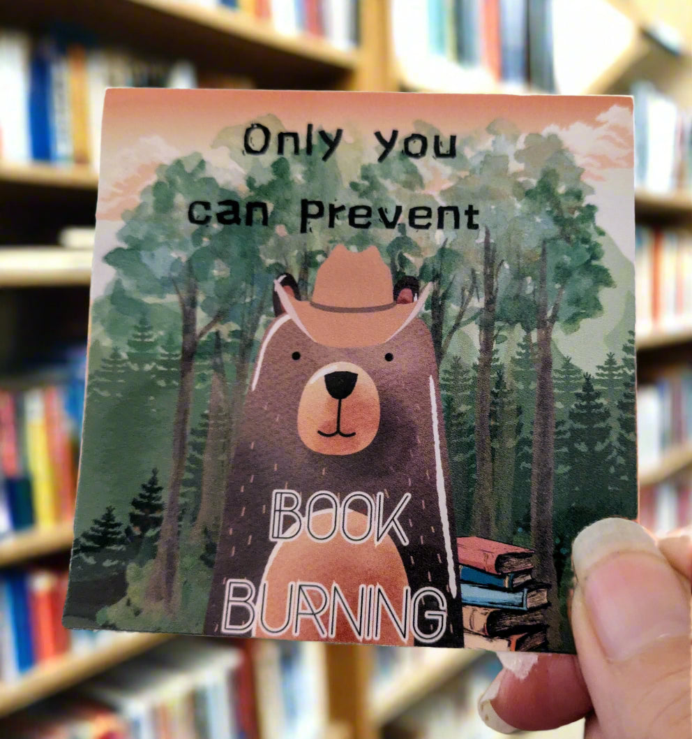 Sticker with bear illustration and text 'Only you can prevent book burning' held by a hand.