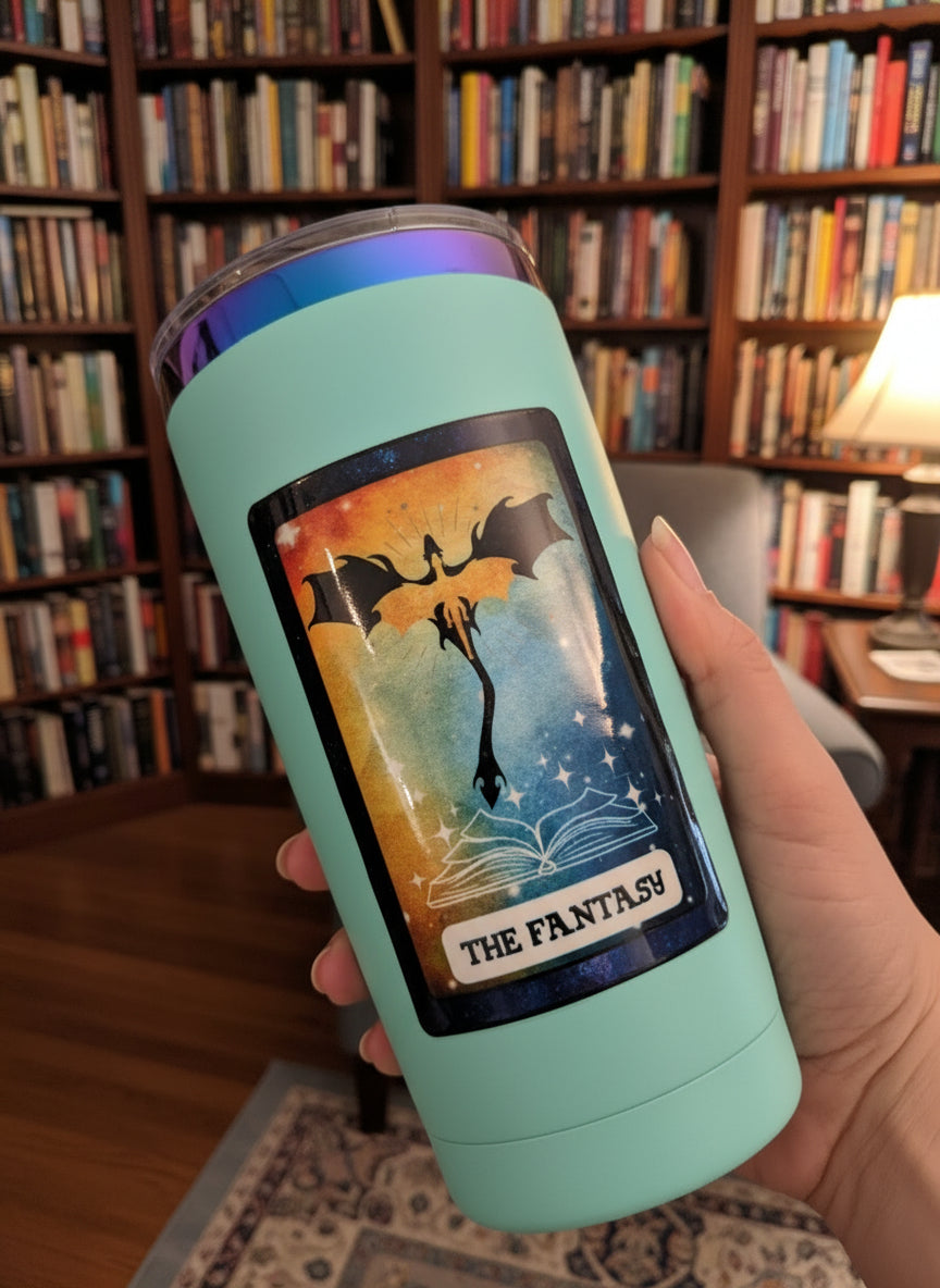 Light blue tumbler with 'The Fantasy' design held by a hand in an indoor setting.