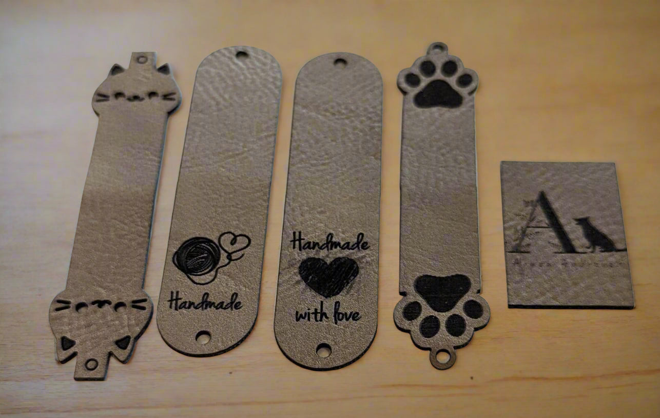 Set of faux leather tags with cat and paw designs on a white background