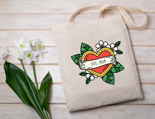 Tote bag with 'Dog Mom' design on a wooden surface with flowers