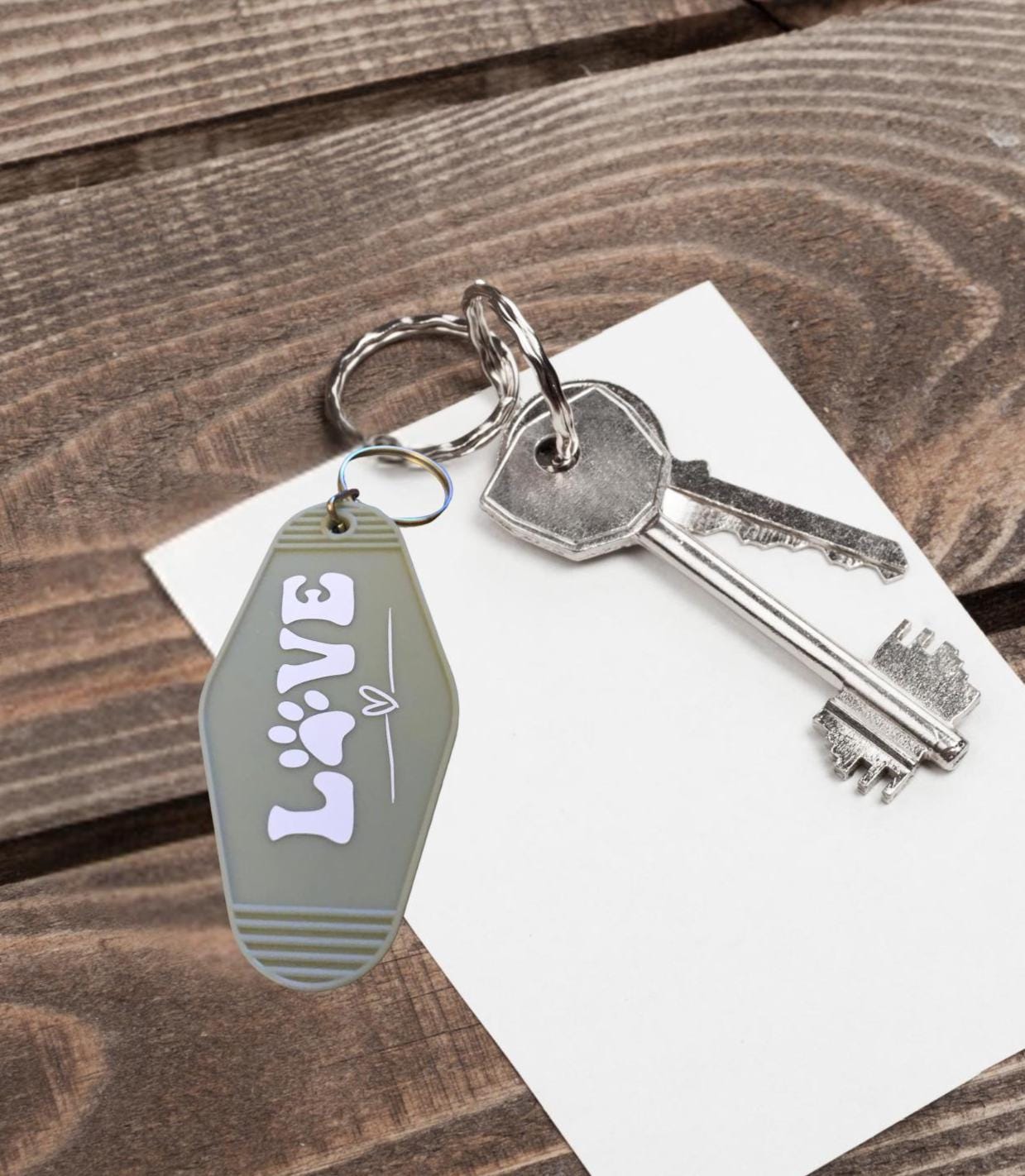 Keychain with 'LOVE' text and a key on wooden surface