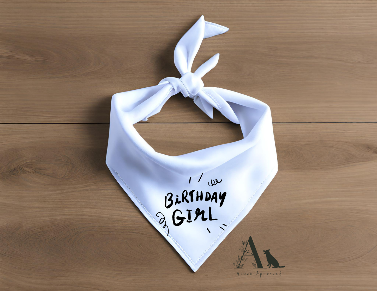 White bandana with 'Birthday Girl' text on a wooden surface