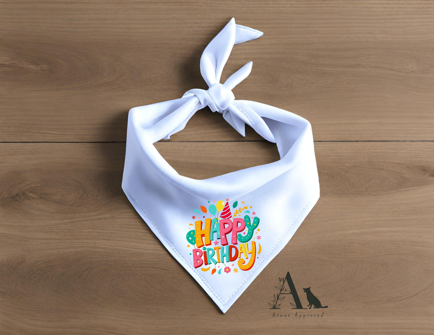 White bandana with colorful 'Happy Birthday' text on a wooden surface