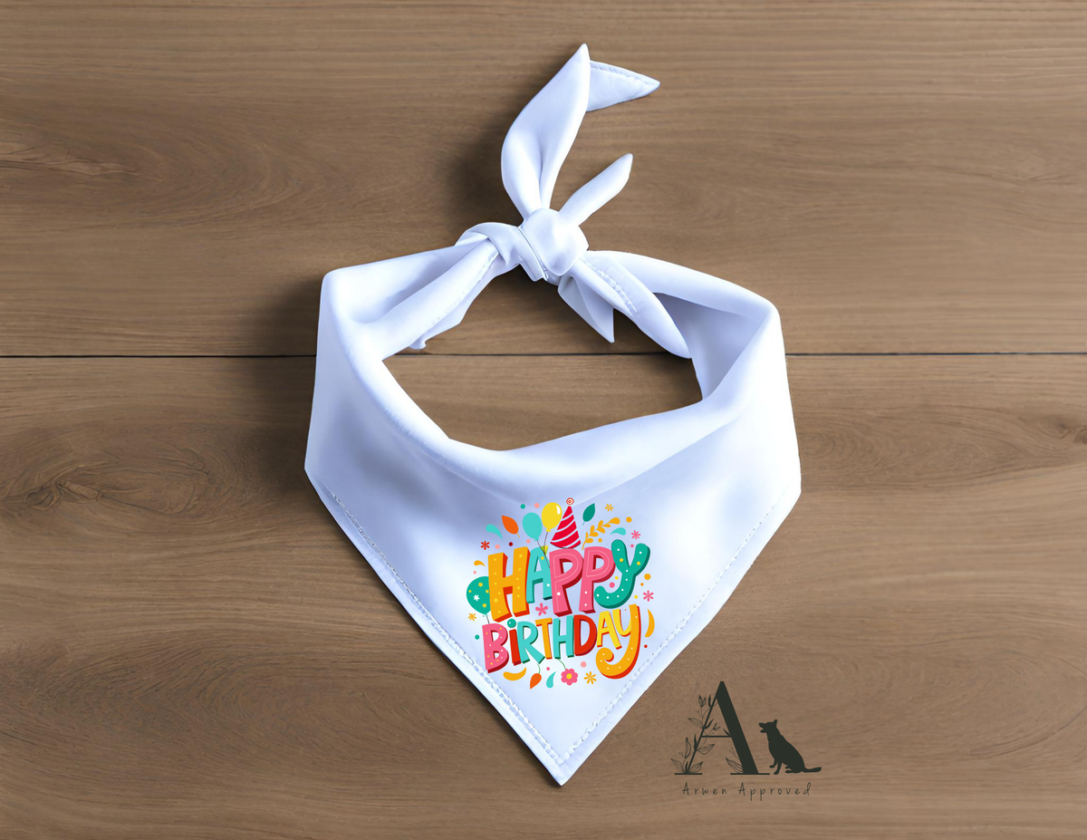 White bandana with colorful 'Happy Birthday' text on a wooden surface