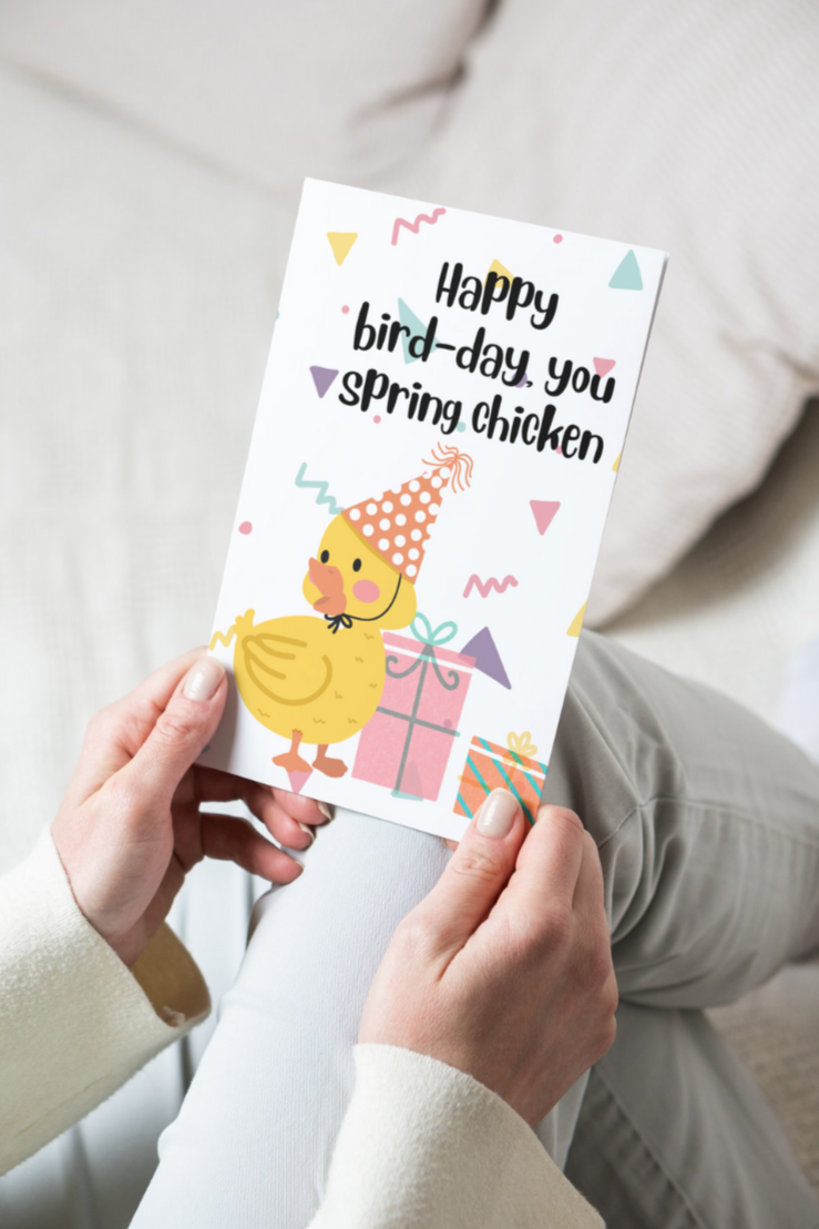 greeting card with a chick wearing a birthday hat and surrounded with presents and text that says happy bird-day, you spring chicken