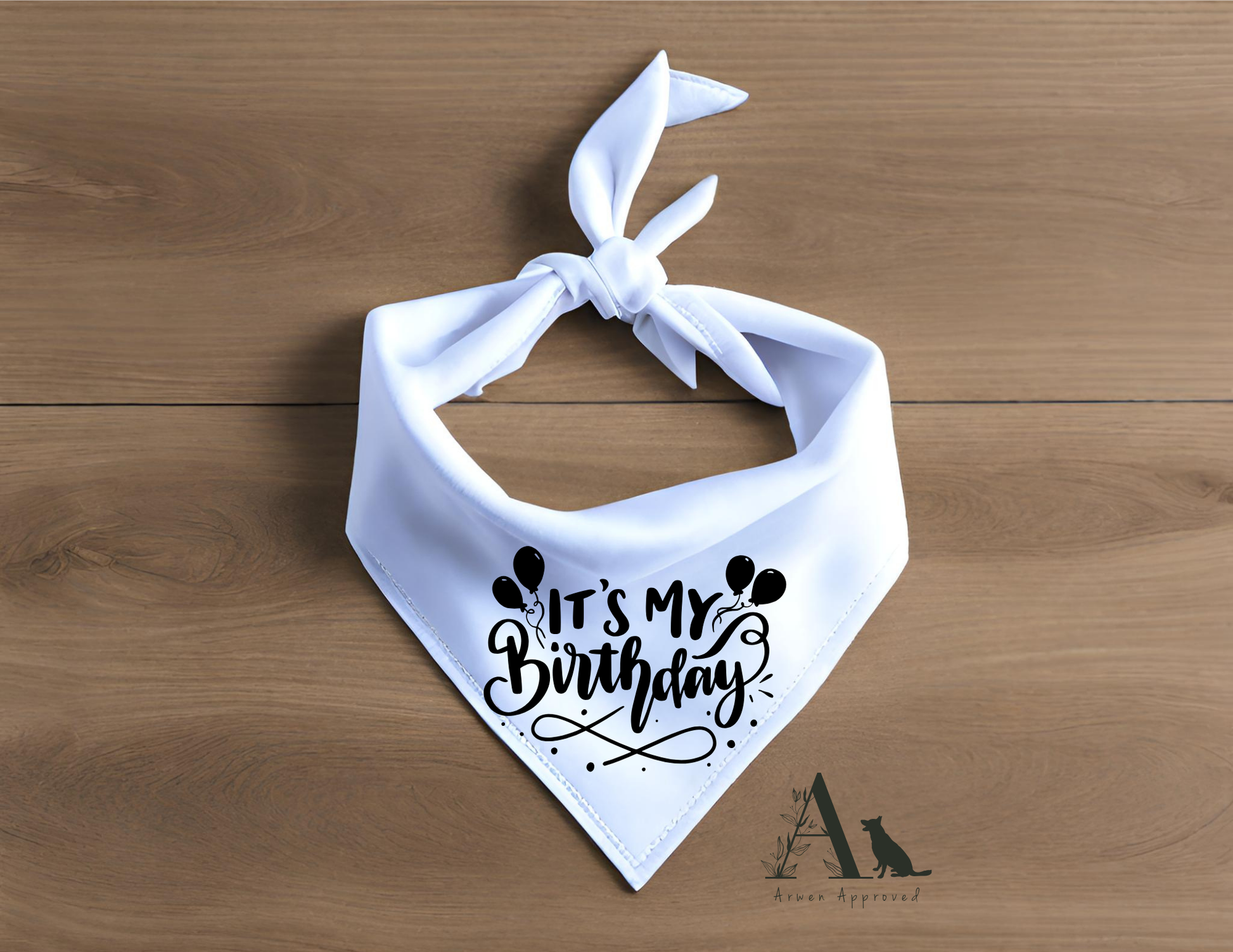White bandana with 'It's My Birthday' text on a wooden surface