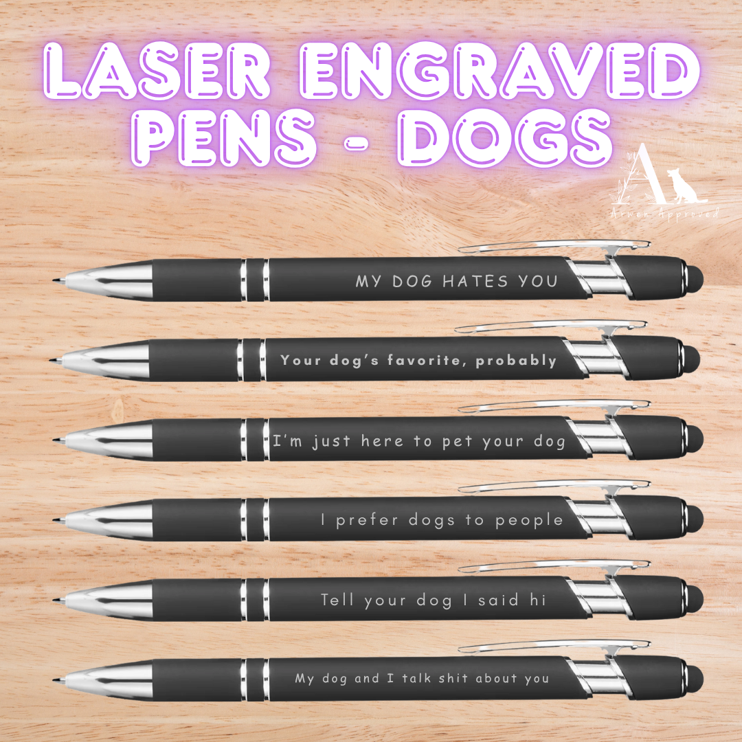 Set of laser engraved pens with humorous text on a wooden surface