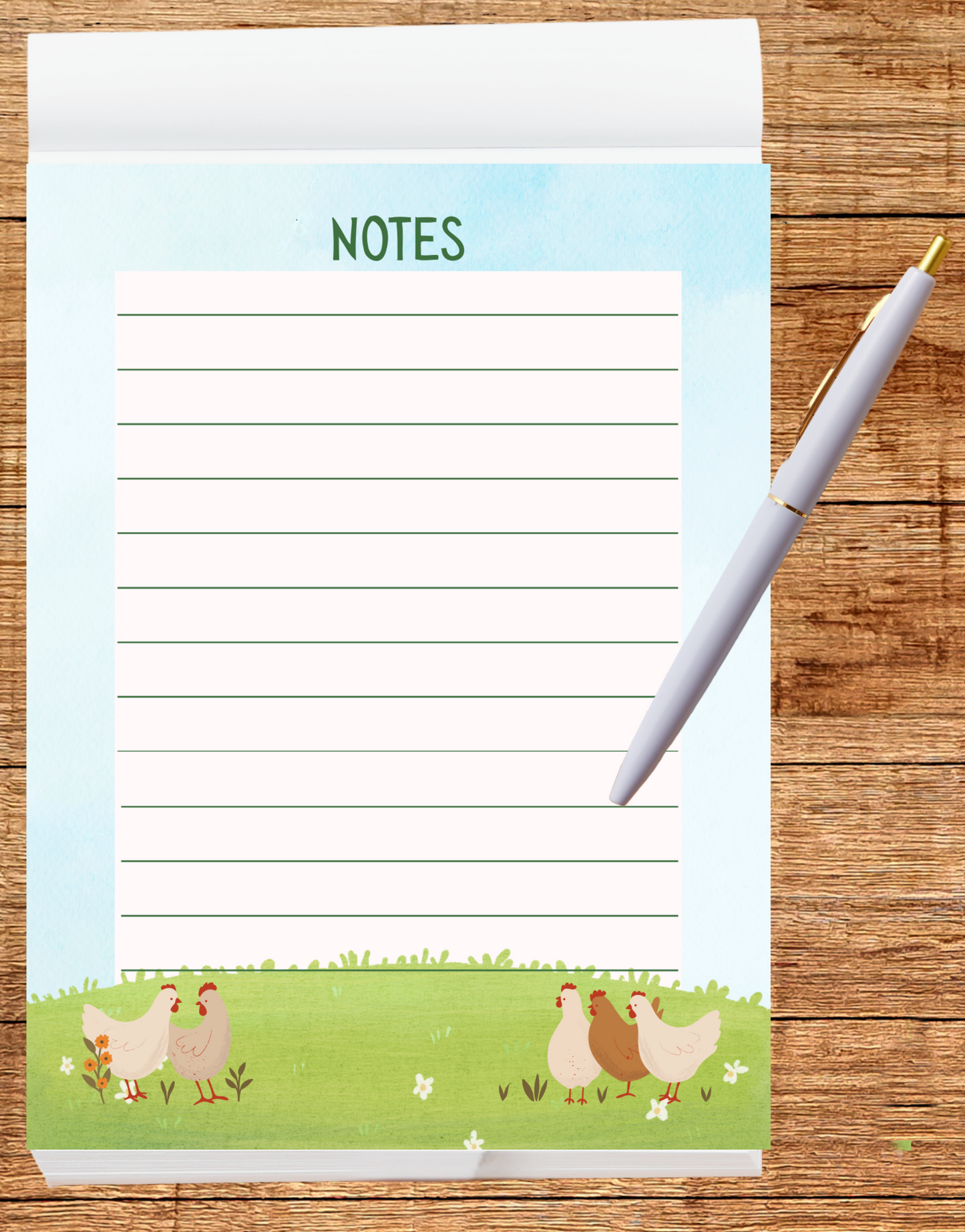 Notepad with chicken design and a pen on a wooden surface