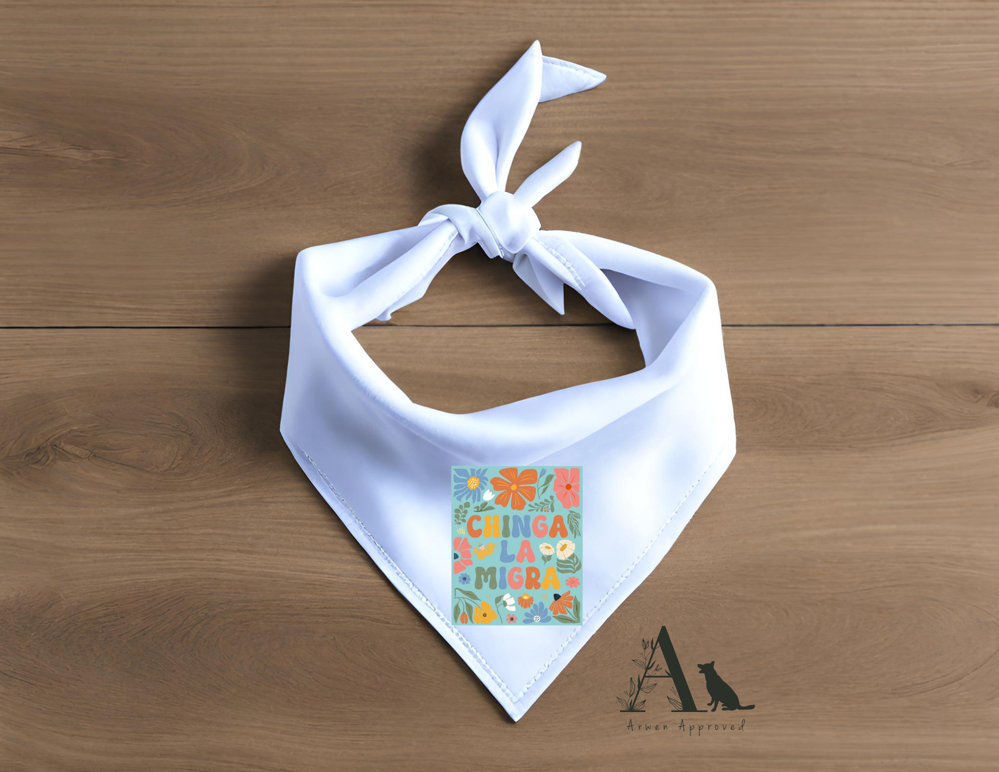 White bandana with colorful 'chinga la migra' design on a wooden surface