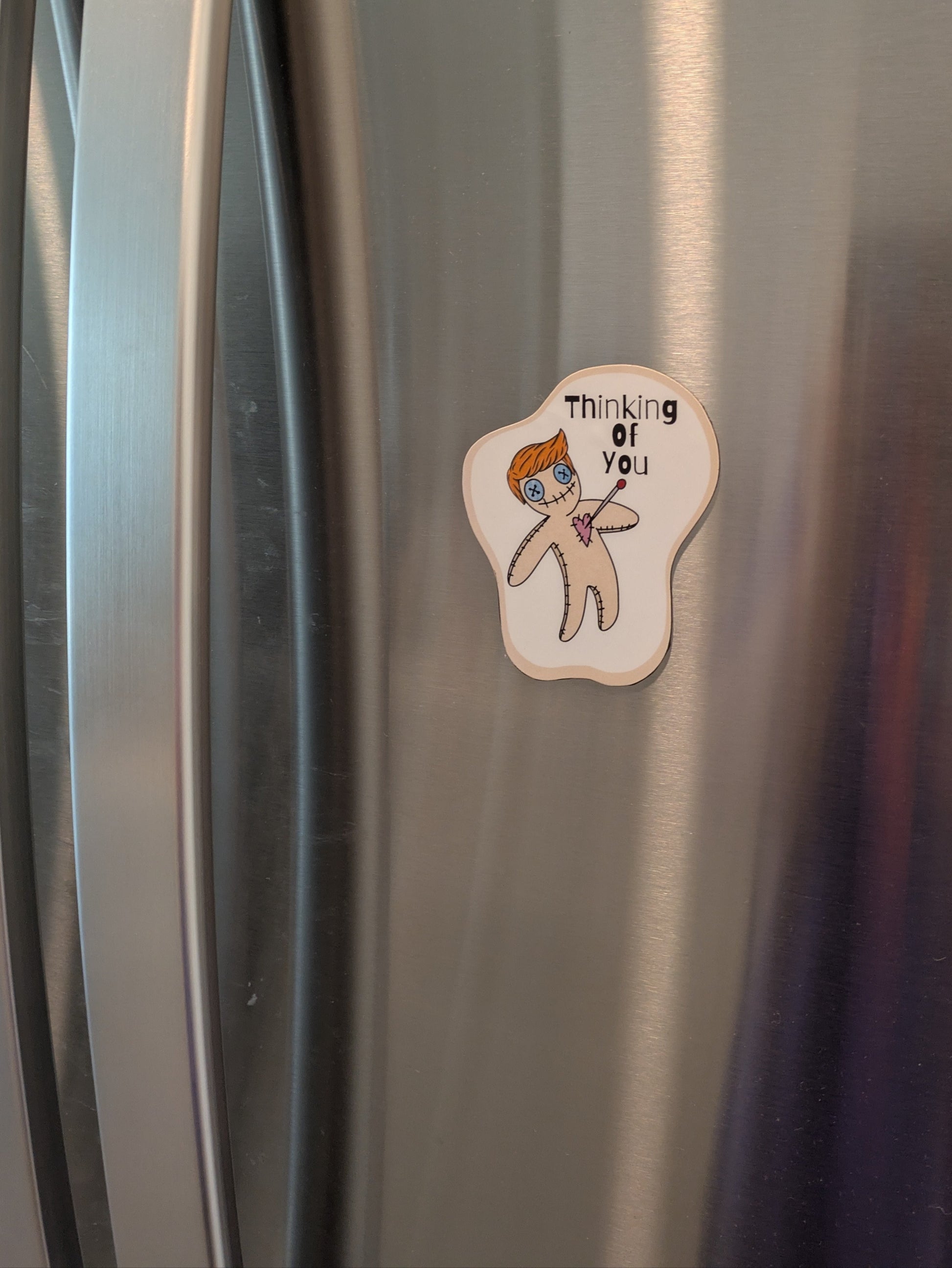 Fridge with a cartoon magnet on a metallic surface