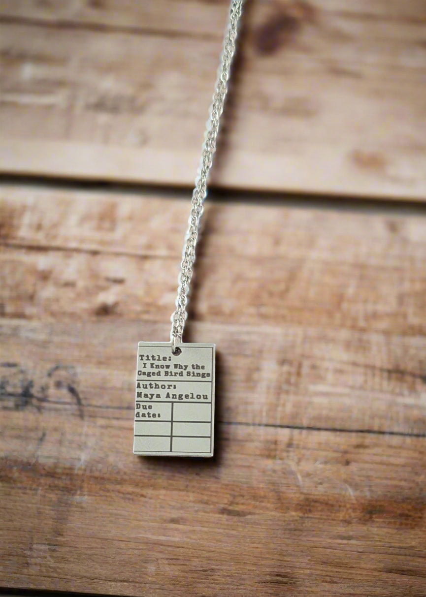 Necklace with a library card design on a wooden surface
