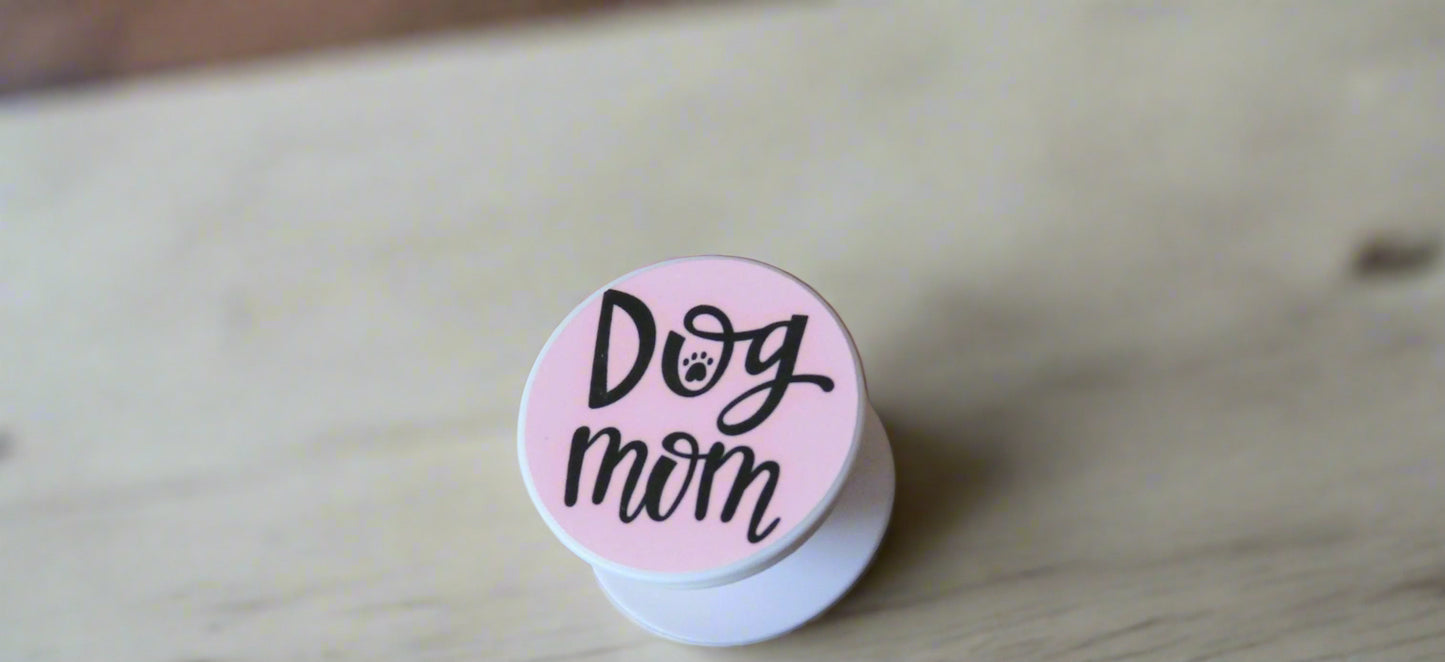 Pop socket phone grip with dog mom printed on a pink background