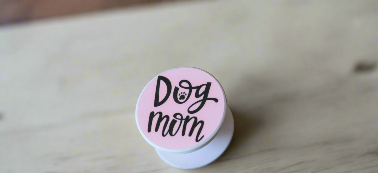 Pop socket phone grip with dog mom printed on a pink background