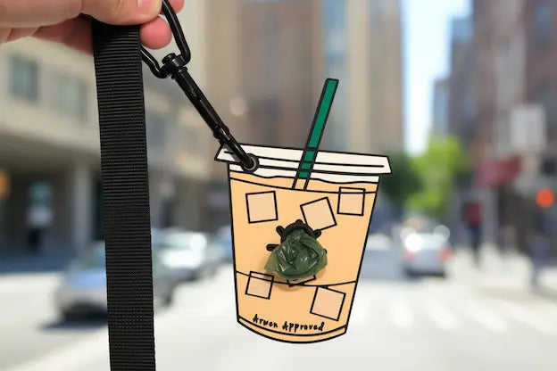 Cartoon-style iced coffee cup poop bag holder a blurred city street background