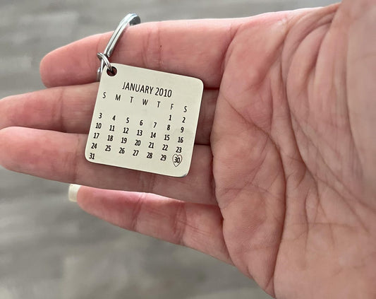Silver calendar keychain with a heart on the important date