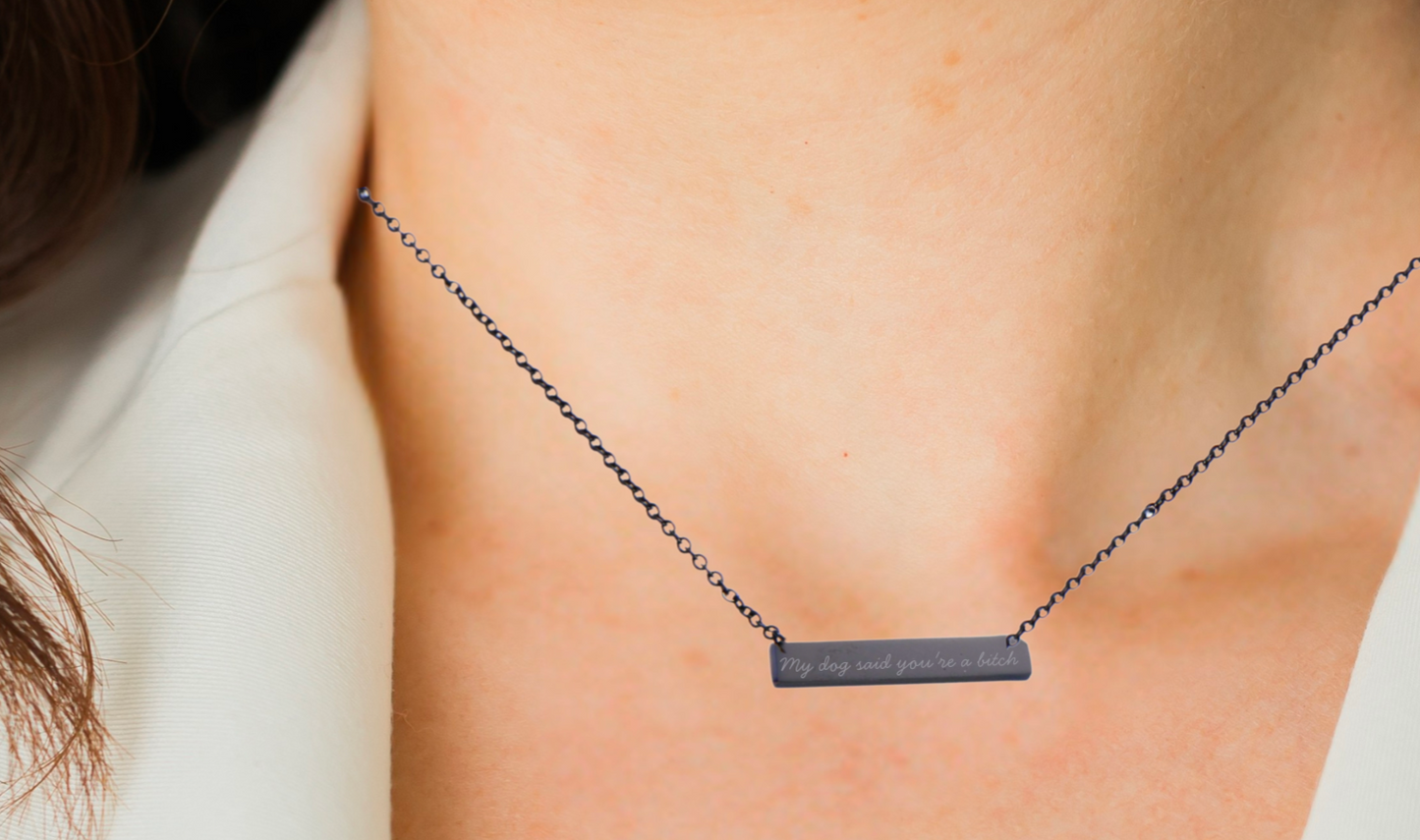 Necklace with a bar charm 'my dog said you're a bitch' on a person's neck